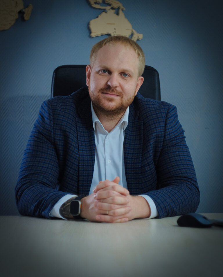 Человек в офисе за столом, обсуждающий лифтовое оборудование