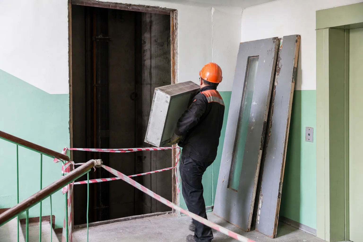 Демонтаж старого лифта в подъезде панельного дома перед установкой нового